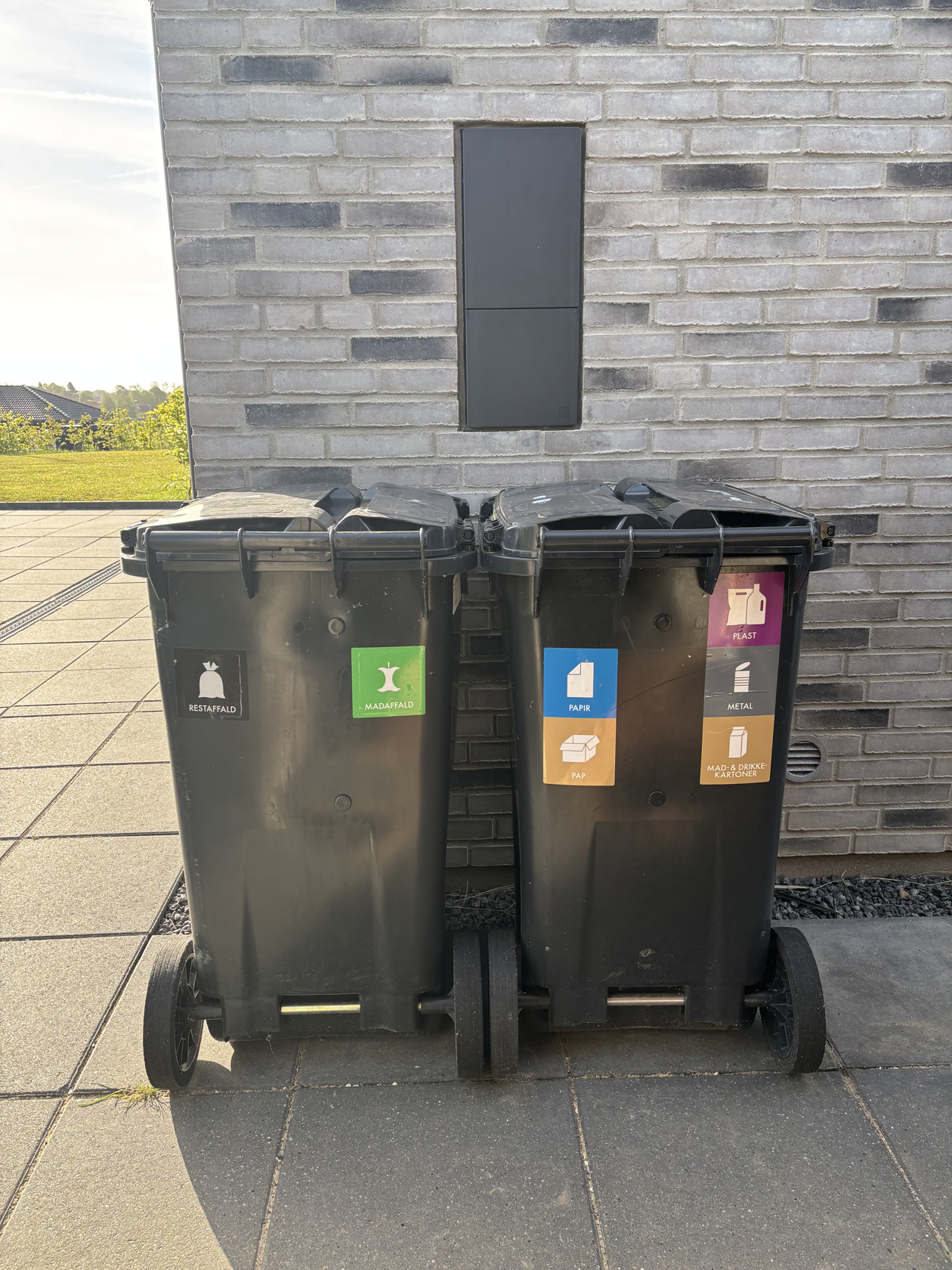 Foto af affalds- og genbrugsbeholdere ved husstand. Foto: Ren Forsyning Mariagerfjord.