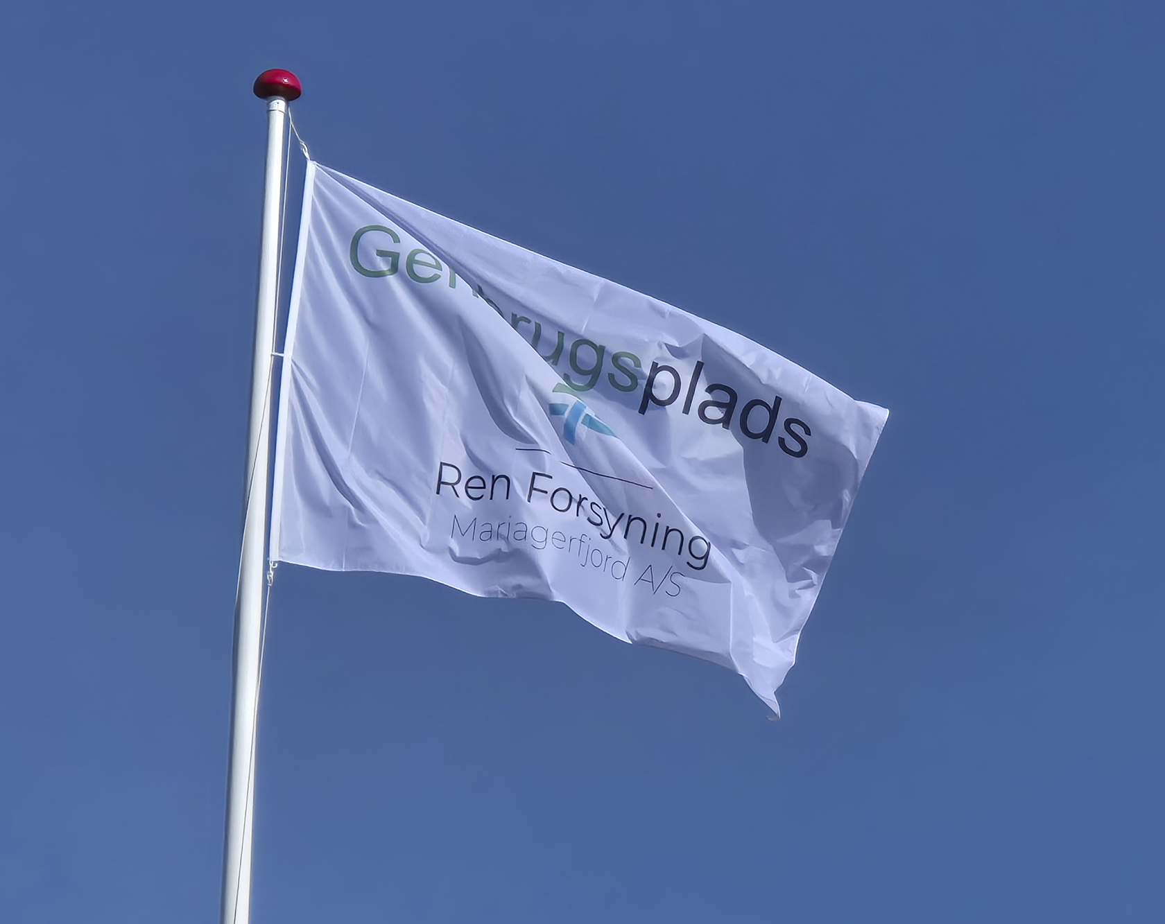 Foto af flag med fra Genbrugsplads med Ren Forsyning Mariagerfjords logo. Foto: Ren Forsyning Mariagerfjord.