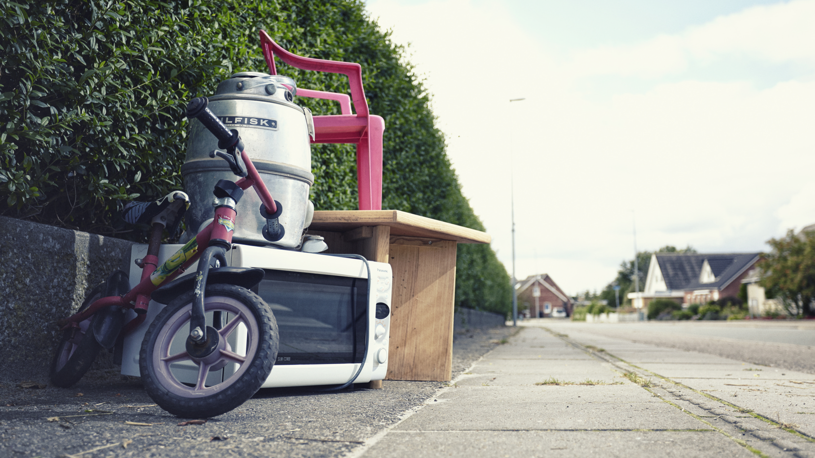Storskrald placeret ved hæk på villavej.